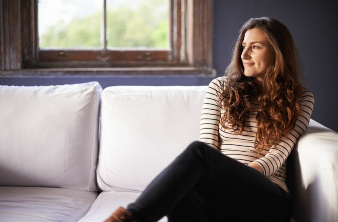 Woman sitting on a couch doing nothing.